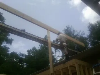 Carpenter setting a ridge beam over a new addition frame — Ice Dam Removal by Roofing Brothers in Rancho Cordova