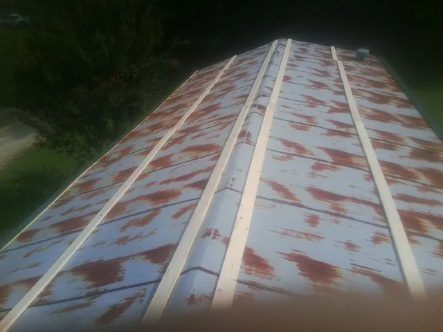 Rusted metal roof panels with new wood purlins before replacement — Storm Damage Roof Repair in Rancho Cordova by Roofing Brothers