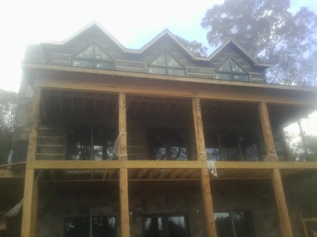 Dormers and porch framing on a large log home under construction — Roof Coating work by our crew in Rancho Cordova