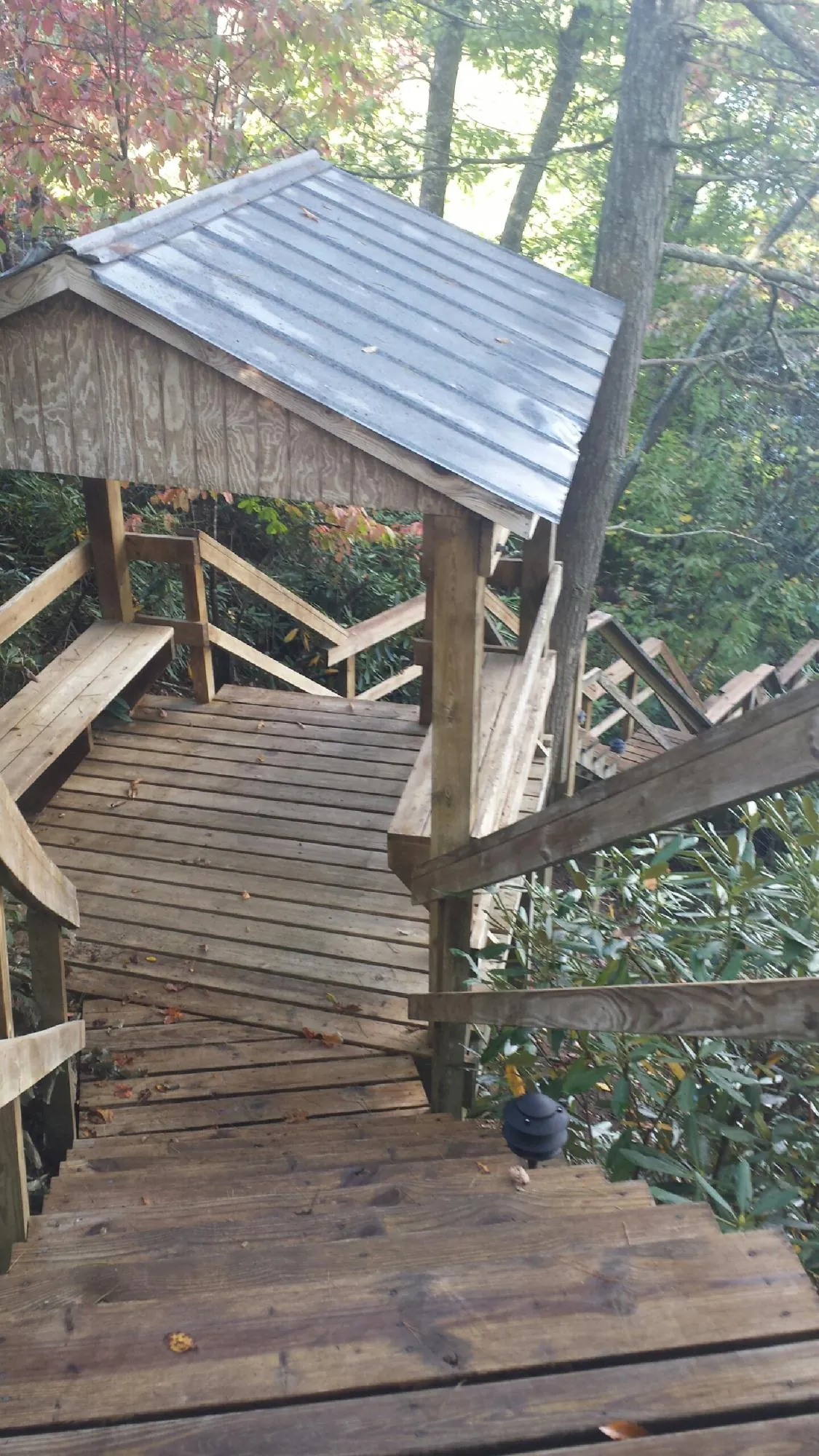 Metal roofed shelter over wooden steps on a wooded walkway — Skylight Repair & Installation work by our crew in Rancho Cordova